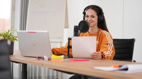 Mitarbeiterin des CJD am arbeiten vor dem Laptop, mit einem Headset und einem Mikrophone
