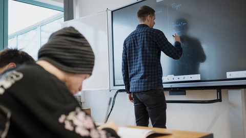 Schüler und Lehrer im Unterricht in einem modernen Klassenzimmer des CJD