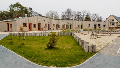 Moderner Holzbau mit großem Außenspielbereich, barrierefreie Kita oder Schule des CJD im Grünen.