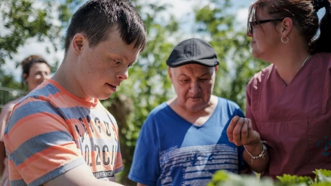 Menschen mit und ohne Behinderung arbeiten gemeinsam im Garten, gelebte Inklusion und Teilhabe beim CJD.