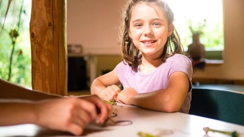 Ein Kind sitzt an einem Tisch.