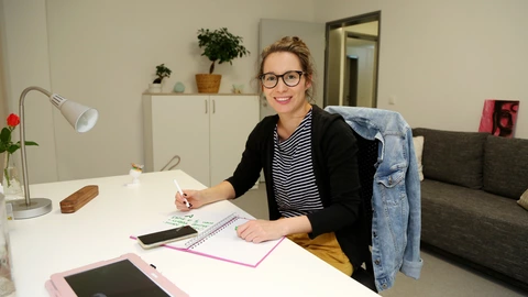 Eine junge Frau an einem Schreibtisch im Studentenwohnheim Ilmenau