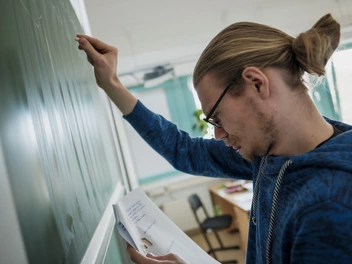 Junger Mann an der Tafel in einem Klassenzimmer einer CJD Schule