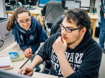 Zwei Auszubildende im Bereich Fachinformatik haben Spaß bei der Arbeit im Büro