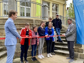 Vor dem neu sanierten Kinderheim wird das rote Band zerschnitten.