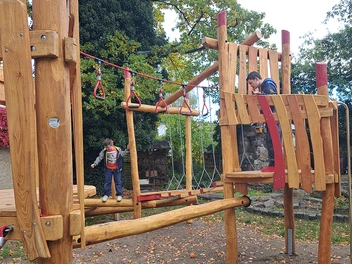 2 Jungen spielen auf der Kletteranlage.