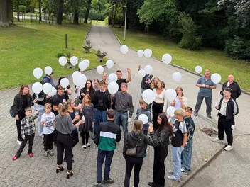 Menschengruppe mit weißen Luftballons