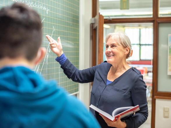 Lehrerin des CJD an der Tafel in einem Klassenzimmer 
