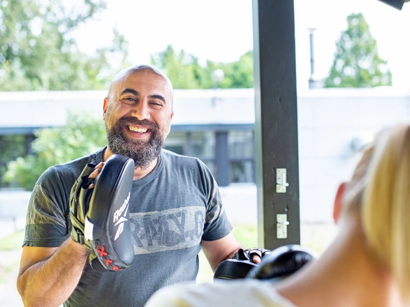 Ein CJD Mitarbeiter mit Box-Handschuhen bei seiner Coaching-Arbeit.