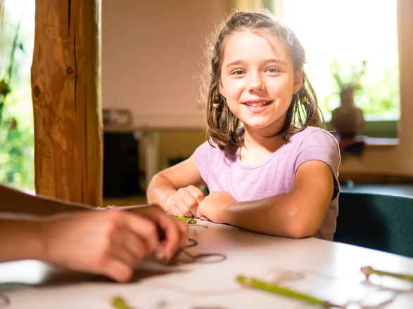 Ein Kind sitzt an einem Tisch.