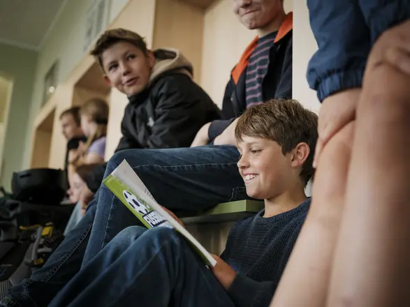 Bild aus dem Schulgebäude, die Schüler haben gerade pause und sitzen zusammen