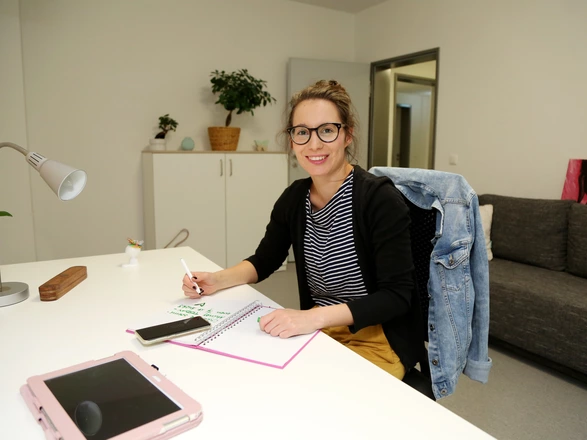 Eine junge Frau an einem Schreibtisch im Studentenwohnheim Ilmenau