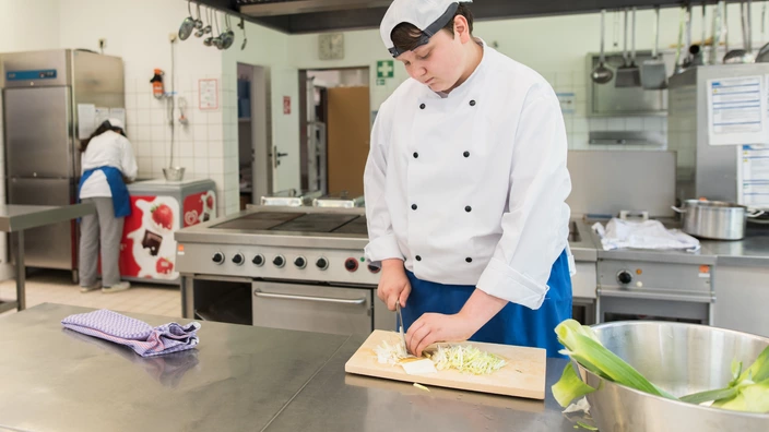 Koch schneidet in Küche Zwiebeln