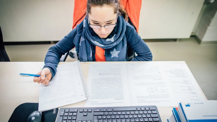 Auszubildende lernt für die Prüfung an ihrem Schreibtisch