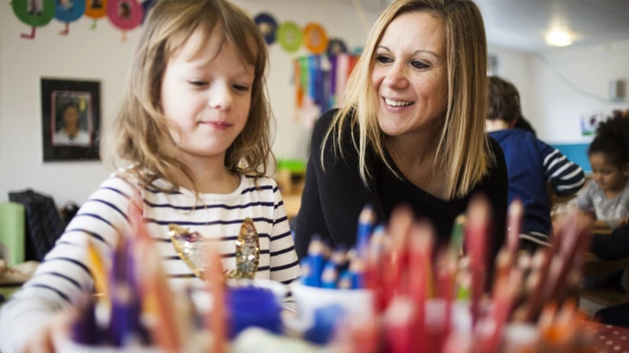Junges Mädchen zeigt Erzieherin ihr Kunstwerk