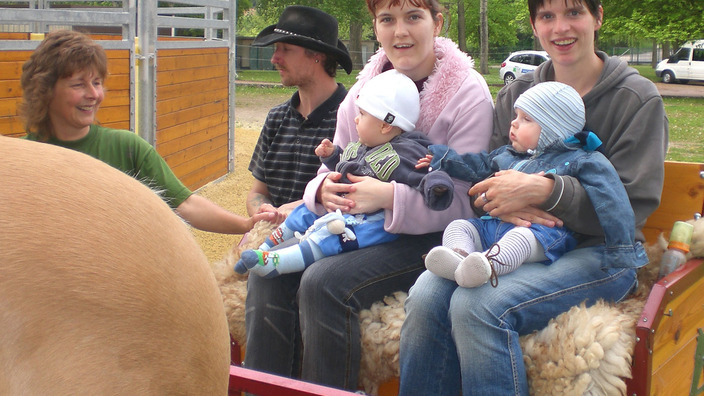 Zwei Mütter sitzen mit ihren Babys auf einer Kutsche