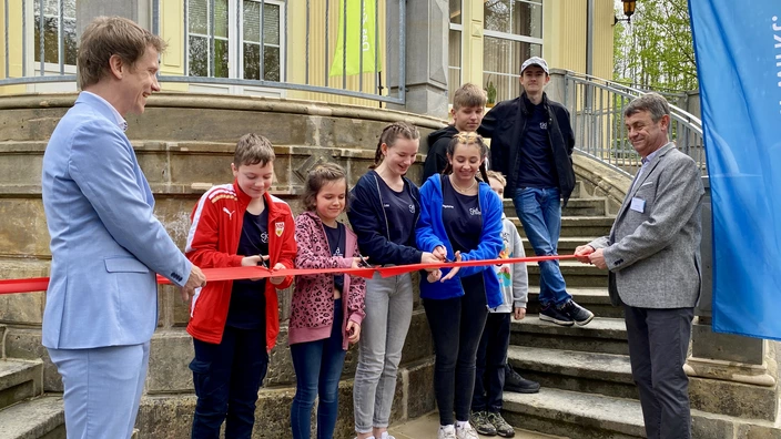 Vor dem neu sanierten Kinderheim wird das rote Band zerschnitten.
