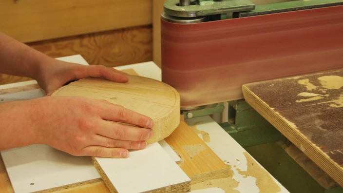 Ein rundes Holzstück wird geschliffen