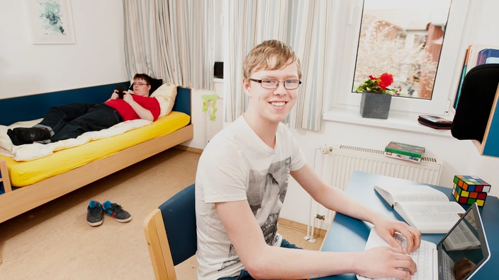 Zwei Jugendliche in einem Zimmer des Wohnbereichs.