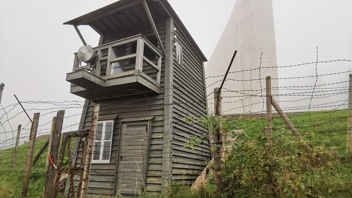 Wachturm mit Mahnmal im Hintergrund