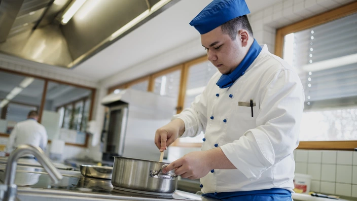 Auszubildender am Herd in der Küche