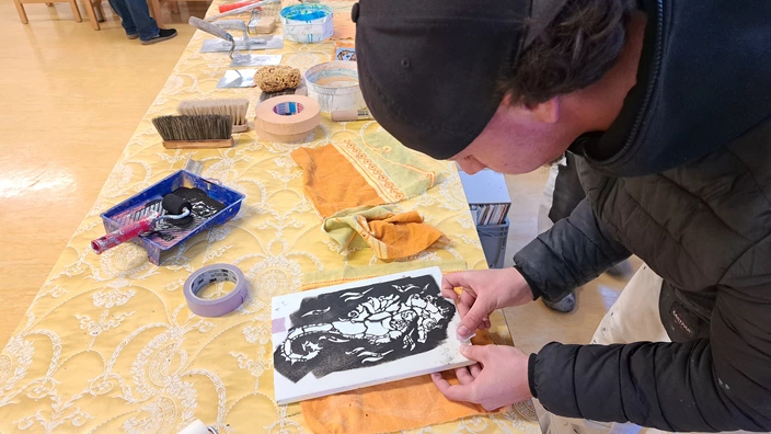 Auszubildender zeigt Technik mit Schablonen im Berufsfeld Malerinnen/Maler und Lackiererinnen/Lackierer im CJD Stuttgart