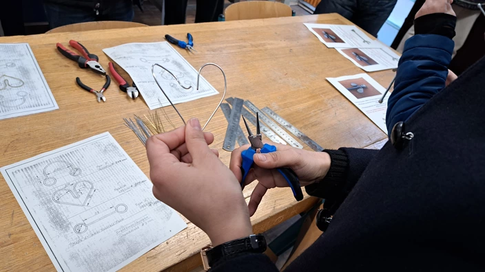 Schülerin formt Herz aus Draht in Metallwerkstatt im CJD Stuttgart