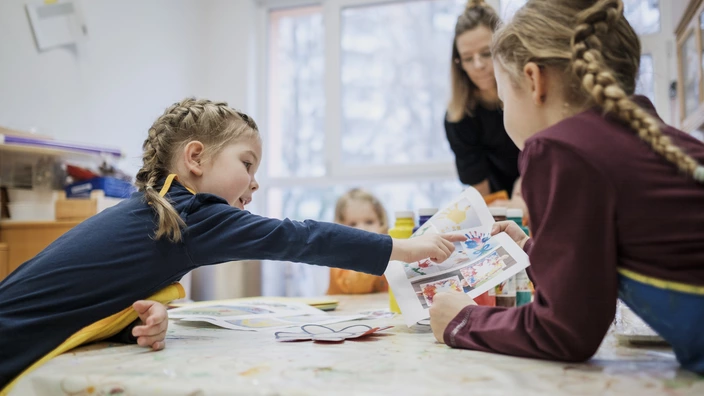 Kinder schauen sich Bilderbuch an 