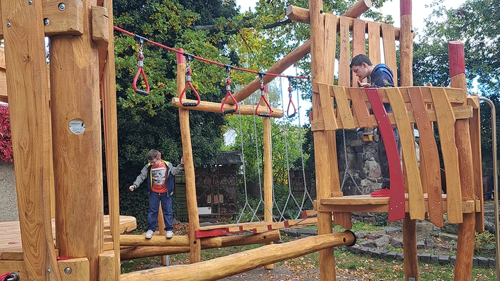 2 Jungen spielen auf der Kletteranlage.