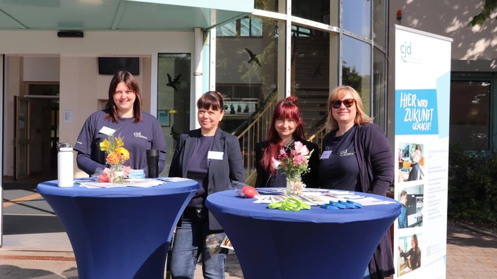 Vier Mitarbeitende an einem Infostand beim Tag der offenen Tür im CJD BBW Gera