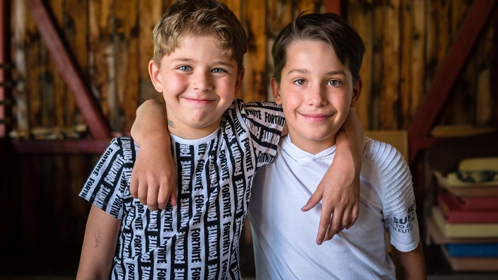 Zwei Kinder lächeln in die Kamera.