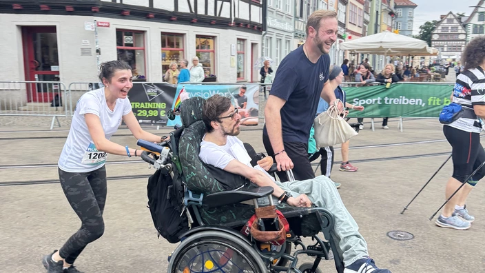 Mit dem Rollstuhl kurz vor dem Zieleinlauf beimDas CJD-Team beim RUN Thüringer Unternehmenslauf 2025 