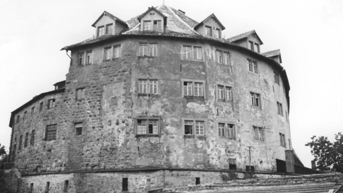 Schwarzweißaufnahme einer alten Burganlage mit massivem, mehrstöckigem Steinbau und zahlreichen Fenstern. Die Fassade ist sichtbar verwittert, teils verputzt, teils aus rohem Stein. Das Dach ist steil und mit Gauben versehen. Es handelt sich vermutlich um das Schloss Kaltenstein, fotografiert in einem frühen Zustand vor der Sanierung, möglicherweise in den 1950er- oder 1960er-Jahren.
