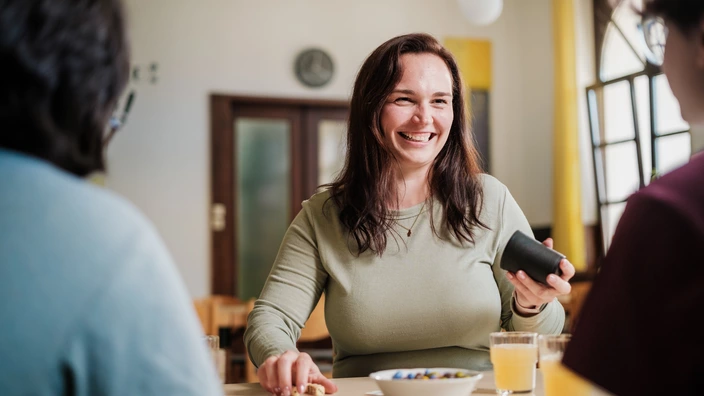 Eine CJD Erzieherin spielt Kniffel mit zwei Jugendlichen.