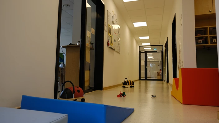 Flur einer Kita, Spielzeug und Rutschfahrzeuge liegen/stehen rum