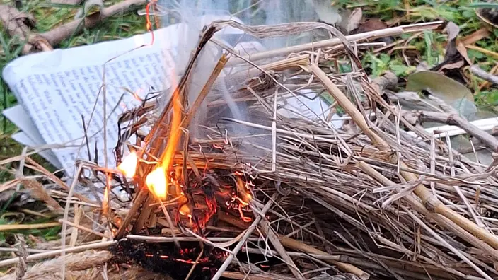 kleine Flamme an trockenem Gras