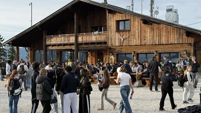Viele Jugendliche vor einem Holzhaus