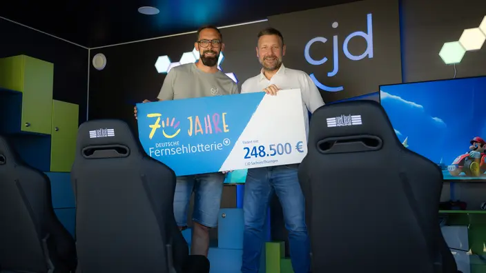Spendenübergabe für Game4All: Fachbereichsleiter Martin Nieher und Stephan Masch, Repräsentant der Deutschen Fernsehlotterie, bei der symbolischen Übergabe der Fördersumme.