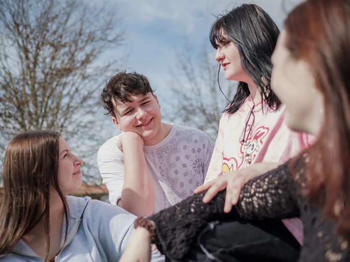 Vier Jugendliche unterhalten sich im Freien