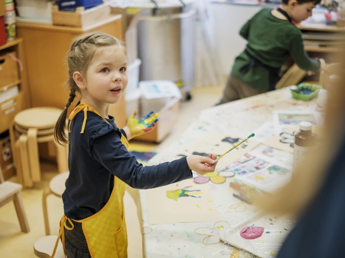 Kleines Mädchen malt mit Wasserfarben in einer Kita des CJD