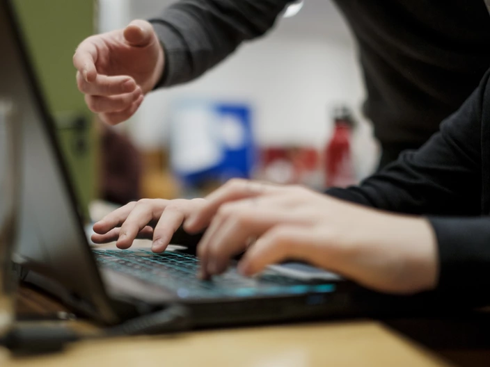 Schüler und Lehrer arbeiten am Computer