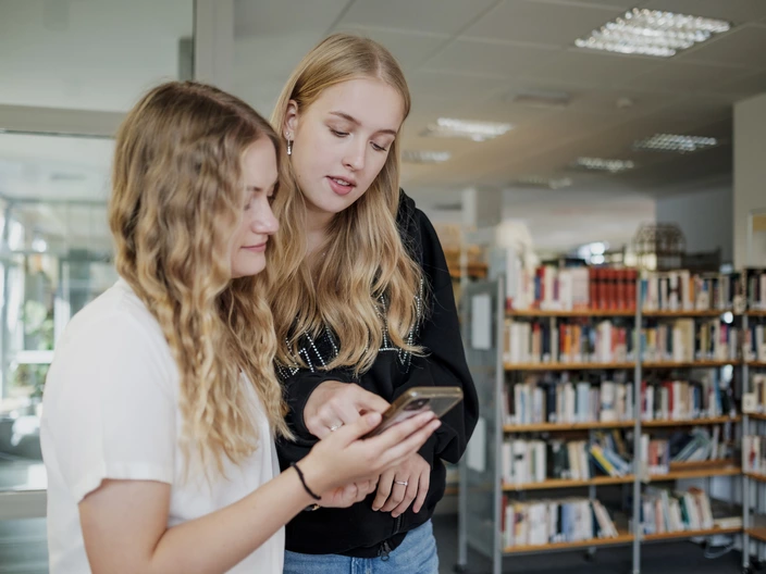 Zwei Jugendliche unterhalten sich über einen Inhalt auf einem Handy