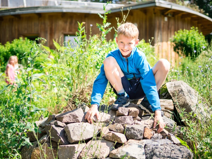 Ein Kind hockt auf einem Steinhaufen.