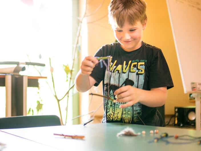 Ein Kind bastelt im Ökohaus.