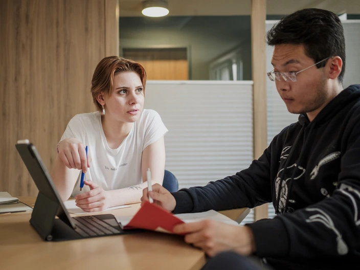 Eine Frau und ein Mann sitzen gemeinsam vor einem Laptop.