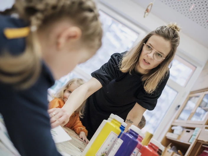 Eine Erzieherin im Gespräch mit Kindern