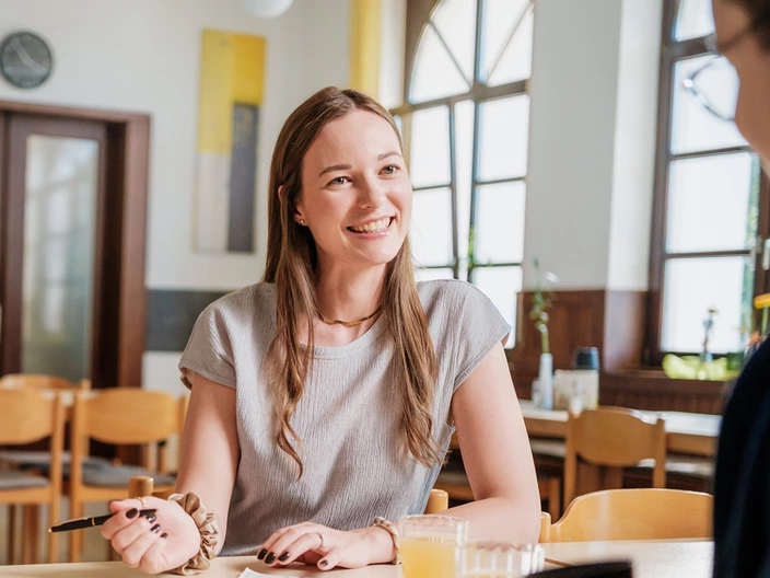Eine CJD Erzieherin notiert etwas, während sie mit einem Jugendlichen spricht.