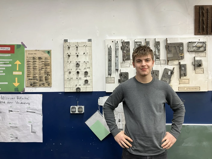 Lennard pausiert vor Werkzeugen in der Metallwerkstatt des CJD